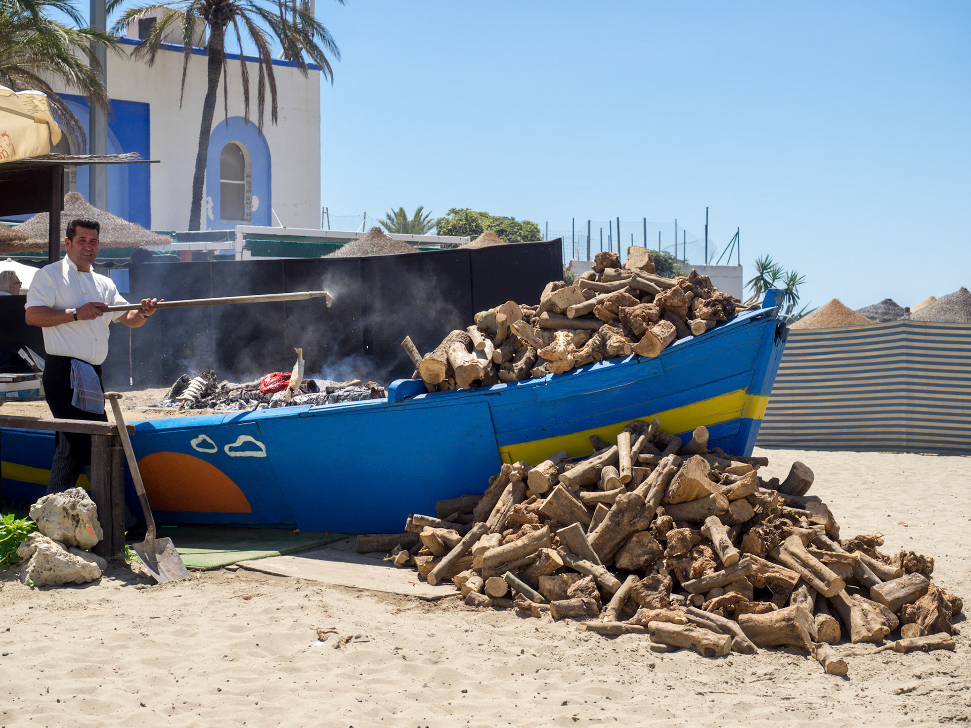 Man Cooking Fish on the Beach in Marbella