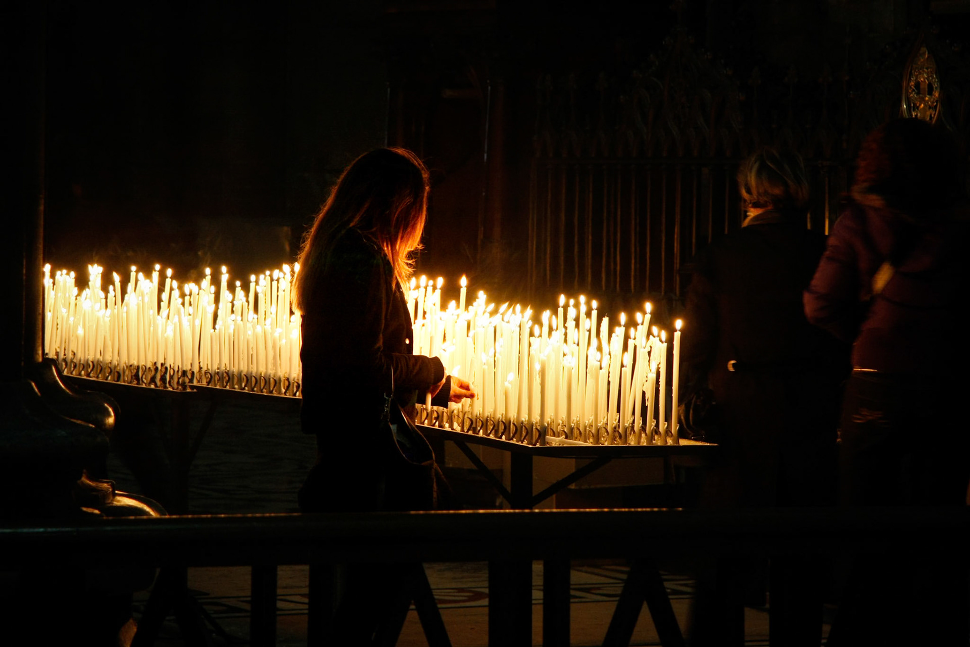 MILAN, ITALY/EUROPE - FEBRUARY 23 : Burning candles in the Duomo Cathedral in Milan Italy on February 23, 2008. Three unidentified people